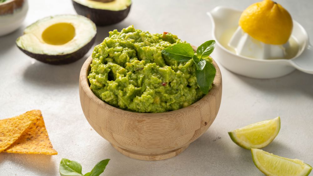 Avocado-Dip in einer Holzschale.