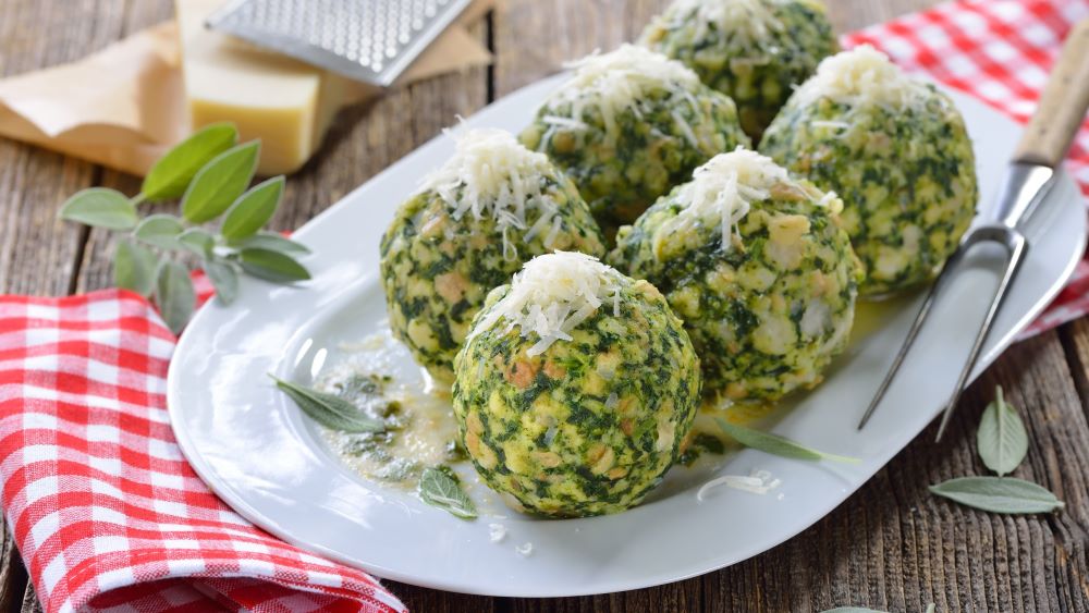 Spinatknödel mit Parmesan auf einem Teller.