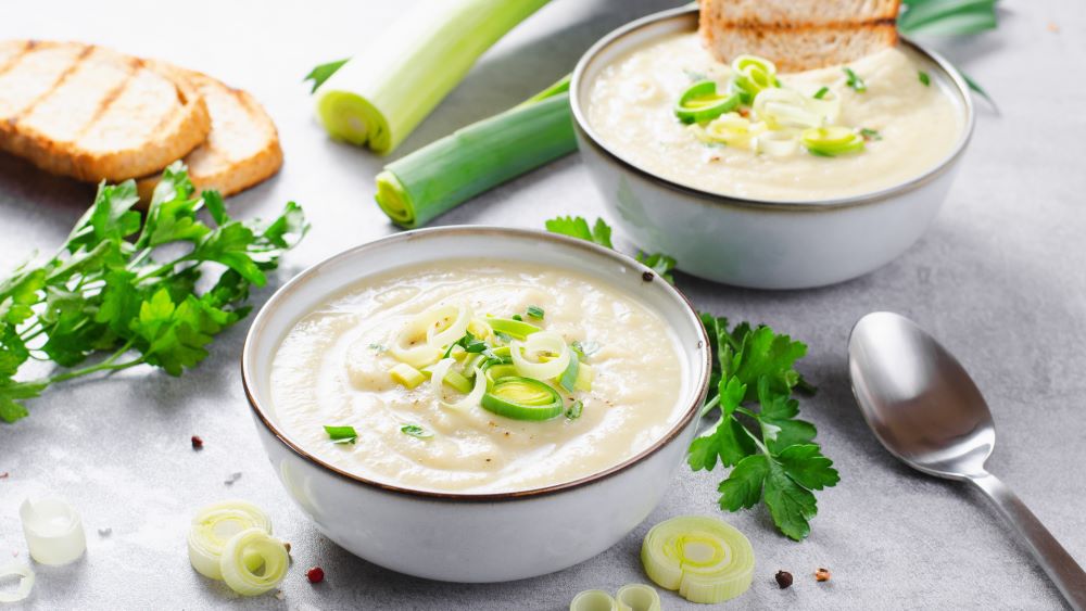 Kartoffel-Lauch-Suppe mit Zutaten in einer Schale.