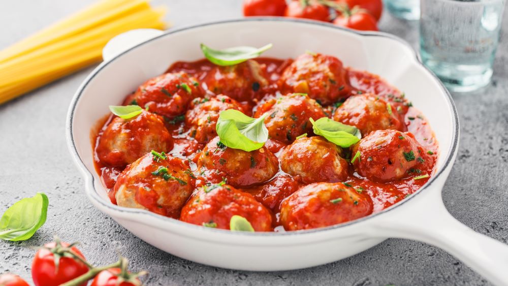 Polpette in Tomatensoße in einer tiefen Pfanne.